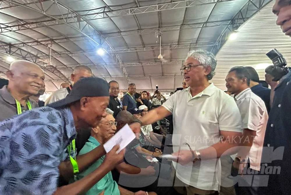 Al-Sultan Abdullah mengurniakan sumbangan kepada mangsa yang terlibat banjir di PSS SK Bunut Rendang pada Sabtu. 