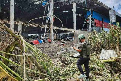 Seorang lelaki memeriksa kawasan rosak akibat serangan udara tentera Thailand di bandar Poipet, wilayah Banteay Meanchey.