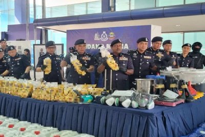 Hussein (enam dari kanan) menunjukkan dadah yang dirampas dalam serbuan dalam Ops Gaharu.