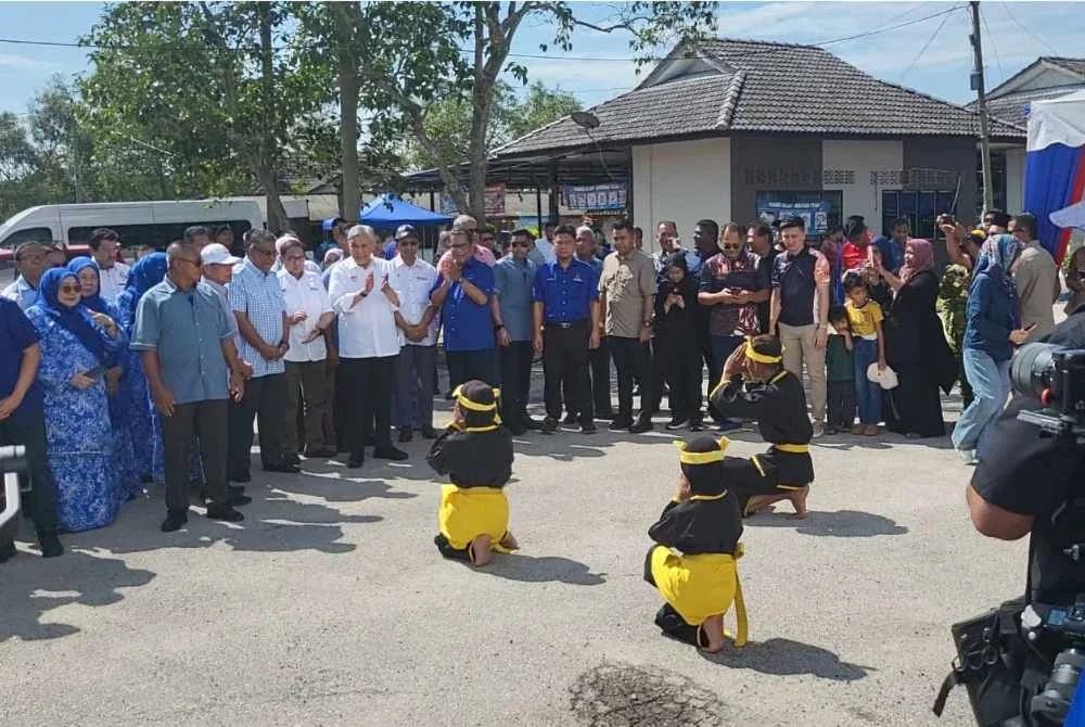 Ahmad Zahid menyaksikan persembahan tarian silat sewaktu tiba di Majlis Pengumuman Lengkap Pakej Lengkap Desa Kirana di Kampung Batu 23, Sungai Nibong pada Sabtu.