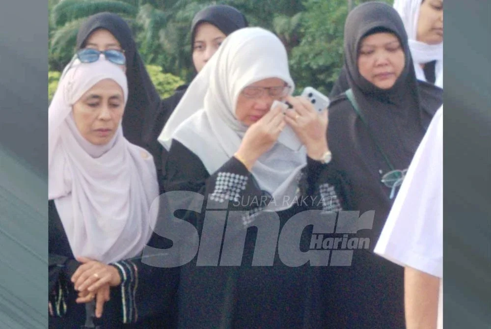Dr Zaliha (tengah) tidak dapat menahan kesedihan di Tanah Wakaf Perkuburan Islam Al-Raudah, Saleng pada Ahad.