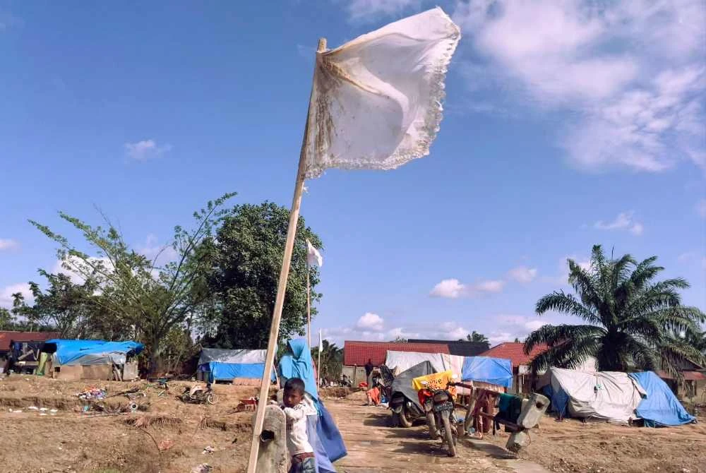 Penduduk di Mukim Langkahan, Aceh Utara mengibarkan bendera putih sebagai tanda memohon bantuan akibat bencana banjir yang memusnahkan ribuan nyawa dan kediaman. - Foto: Bernama