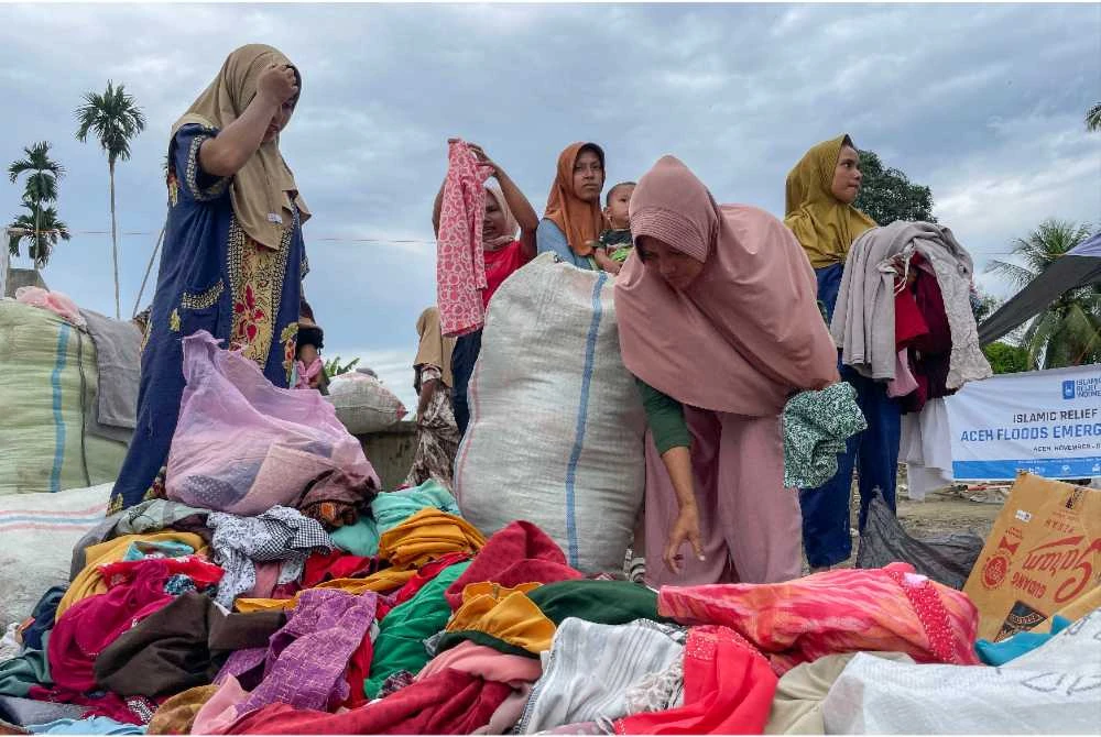 Penduduk Kampung Geudumbak, Mukim Langkahan, Aceh Utara mengambil pakaian yang disumbangkan pelbagai pihak. - Foto: Bernama