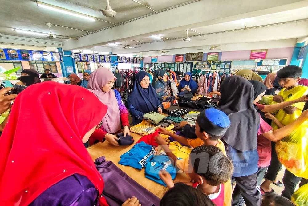 Faizah Hanum bersama rakan guru SMK Bukit Rangin menggerakan inisiatif kosongkan almari dengan niat memberi pakaian percuma kepada mangsa diPPS. Foto Sinar Harian.