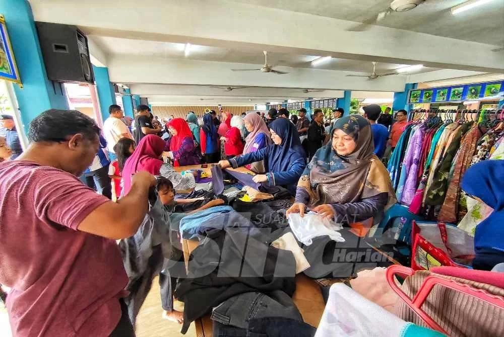 Mangsa yang berlindung di PPS SMK Bukit Rangin mengambil kesempatan memilih pakaian yang disediakan secara percuma di penempatan itu. Foto Sinar Harian.