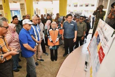 Wan Rosdy (tiga dari kiri) mendengar taklimat ringkas semasa melawat mangsa-mangsa banjir di dua PPS di Bera pada Ahad. FOTO FB WAN ROSDY WAN ISMAIL