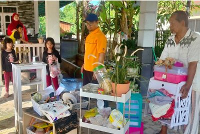 Sa'ari sibuk membersihkan rumah dibantu Mohamad Khairul Furzan.