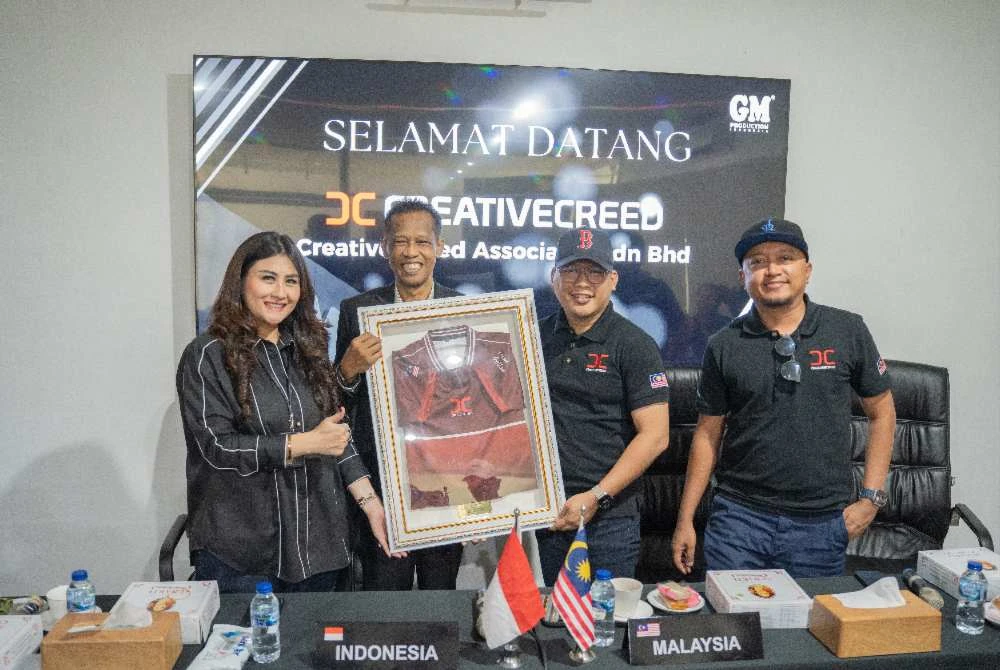 Syaiful Bakhtiar (dua dari kanan) menyerahkan cenderamata kepada Bapak Sutikno (dua dari kiri) ketika lawatan mereka ke ibu pejabat GM Production di Yogyakarta.