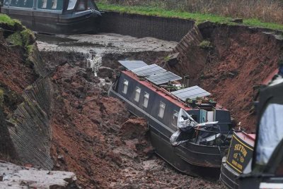 Bot-bot rosak kelihatan terdampar selepas sebuah lubang benam menyebabkan terusan pecah di Whitchurch, Shropshire, England. Foto AP