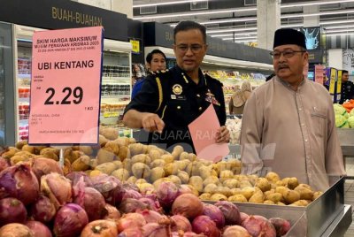 Azman (kiri) bersama Md Anizam memeriksa harga barangan semasa majlis pelancaran Skim Harga Maksimum Musim Perayaan Krismas di Mydin Tunjong, Kota Bharu pada Selasa. 