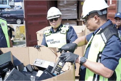 Mohamad Azhar (kiri) menunjukkan antara rampasan e-waste yang dirampas JKDM di Pelabuhan Klang pada 8 Oktober lalu. Foto: JKDM Selangor