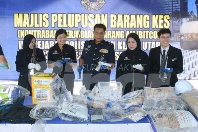 Mohd Rahimi (tengah) menunjukkan pistol dan senjata tajam yang dilupuskan pada Selasa. Foto: SINAR HARIAN/MOHD HALIM ABDUL WAHID
