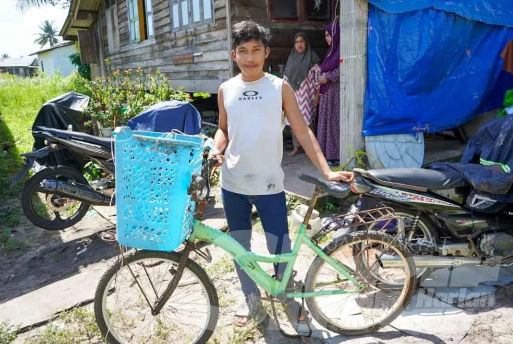 Mohd Firdaus menunjukkan basikal yang digunakan untuk mencari kerja sampingan ketika di bangku sekolah.