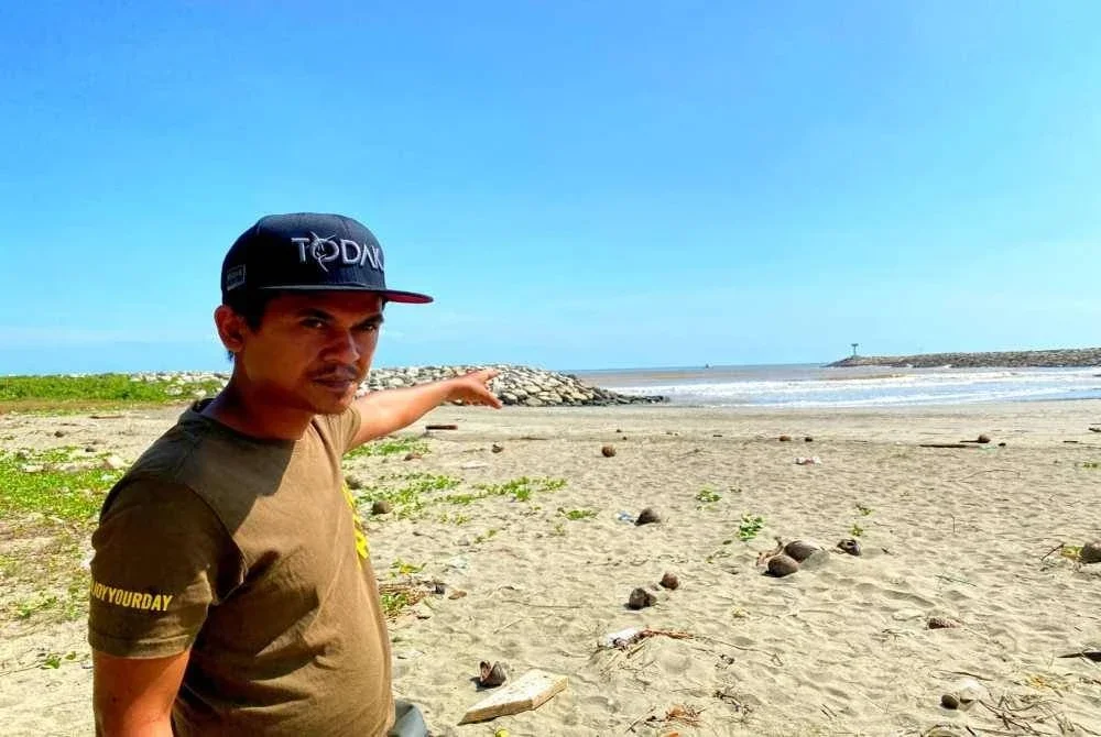 Nazrul menunjukkan lokasi anak saudaranya, Muhamad Irfan bermain air sebelum dihanyutkan ombak besar di Pantai Kemayan, Bachok pada Rabu. Foto Sinar Harian/Hazelen Liana Kamarudin