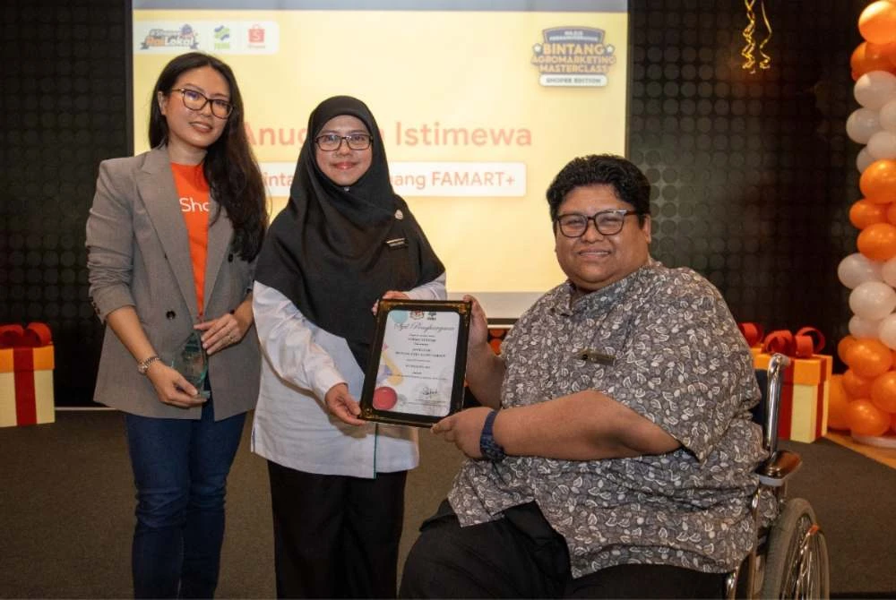 Ketua Hal Ehwal Korporat Shopee Malaysia, Nadia Anwar (kiri) dan Pengarah Kanan Bahagian Keusahawanan Pemasar FAMA, Siti Nurul Haida Ibrahim, menyampaikan Anugerah Khas kategori Bintang Daya Juang kepada Mansur Remely, usahawan produk pertanian organik sempena Majlis Penganugerahan FAMART di ibu pejabat Shopee Malaysia baru-baru ini.