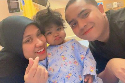 Medina di samping ibu bapanya sebelum menjalani pembedahan pemindahan hati di China pada Selasa.