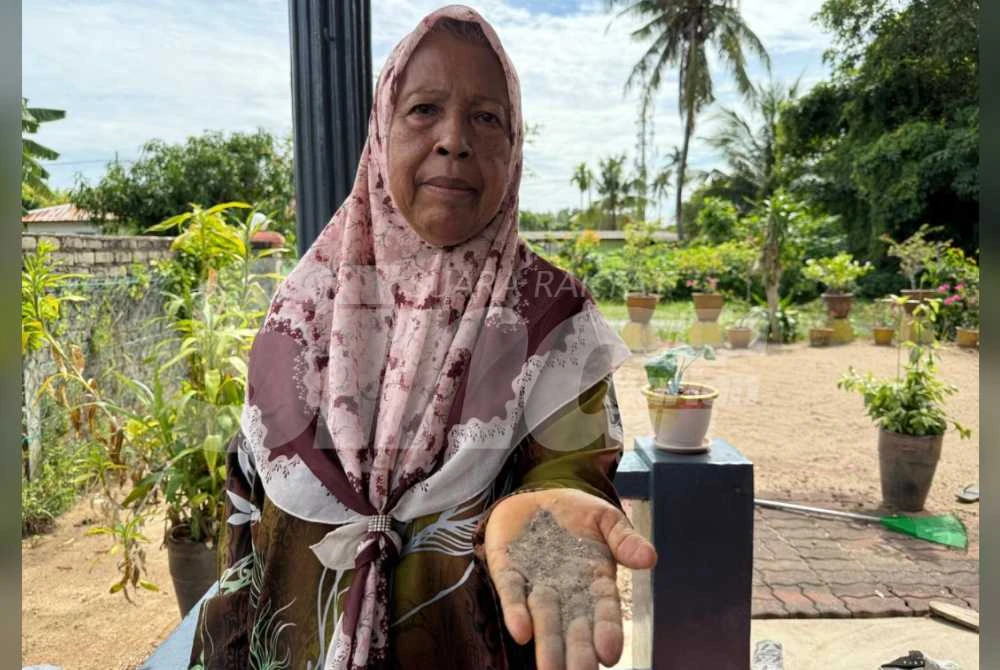 Hamidah menunjukkan sisa habuk yang dikumpulkan untuk tujuan sampel kualiti udara di kampung berkenaan.