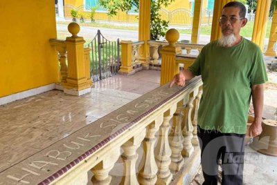 Ramlan menunjukkan kesan debu dan habuk sisa kelapa sawit di sebuah rumah penduduk.