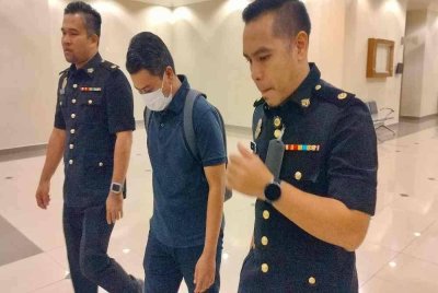 Tertuduh diiringi pegawai SPRM keluar dari mahkamah selepas dijatuhkan hukuman.