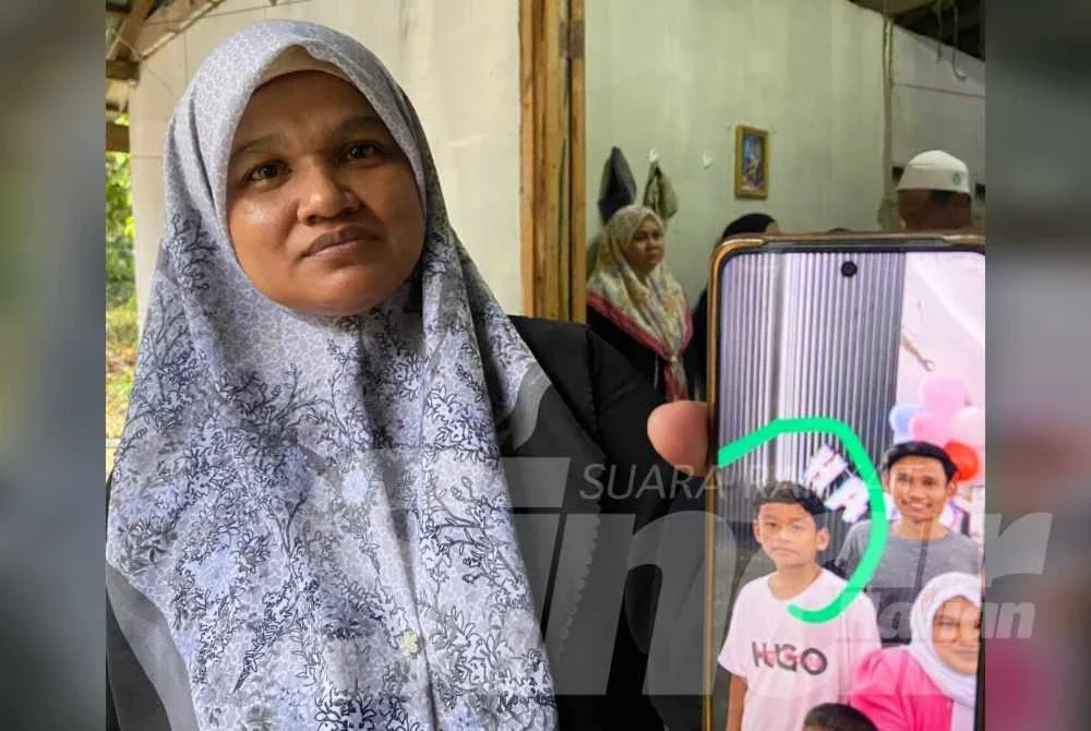 Norzaizura menunjukkan gambar Mohamad Syafi Irsyad semasa ditemui di rumahnya di Kampung Banggol Judah, Machang pada Sabtu. 