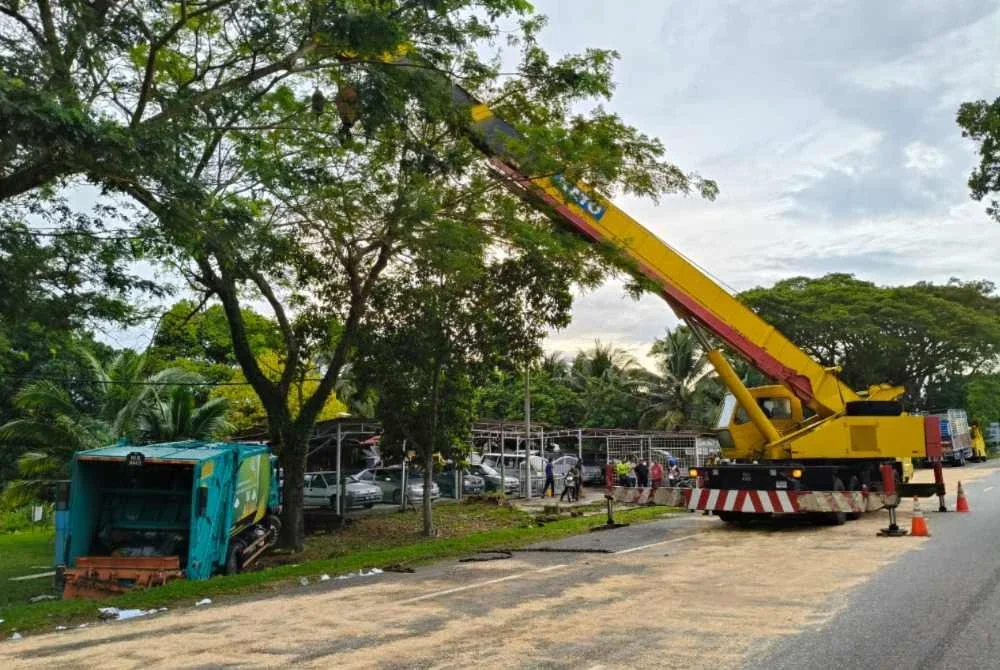 Kerja pengalihan lori sampah yang terbabas. Foto IPD Melaka Tengah