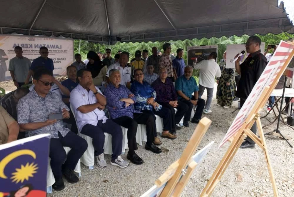 Ahmad Zahid (duduk, tiga dari kiri) mendengar taklimat perkembangan Pembangunan Pusat Data di Bagan Datuk hasil kerjasama strategik antara Kementerian Kemajuan Desa dan Wilayah, MARA Inc, Silver Streams dan FELCRA.