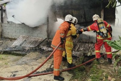 Anggota bomba memadam kebakaran rumah di Kampung Chuchuh Puteri B, Kuala Krai pada Sabtu. Foto JBPM