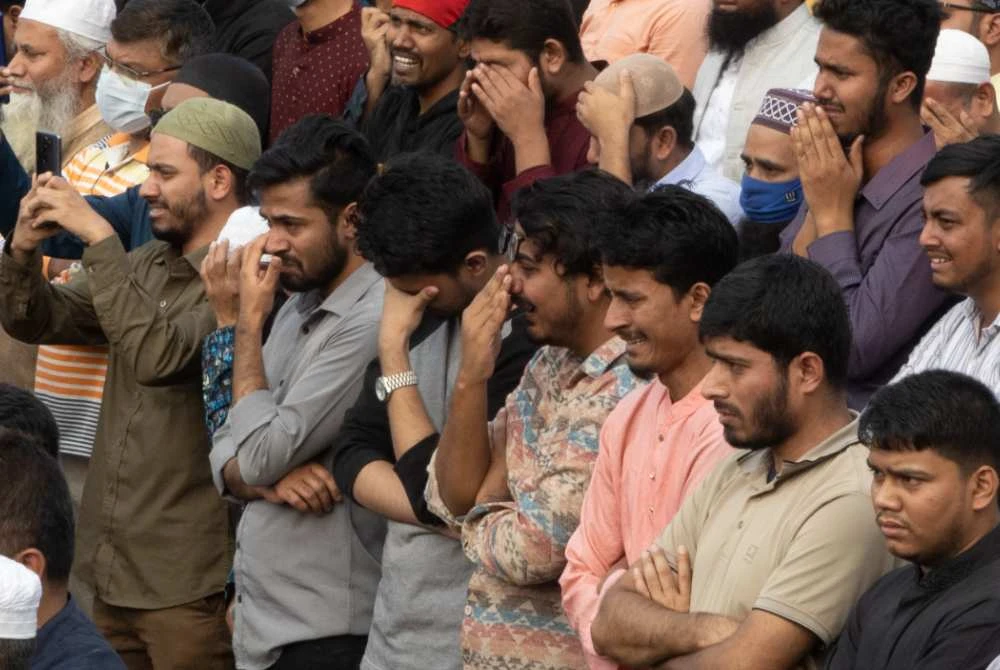 Orang ramai menzahirkan rasa sedih ketika menghadiri upacara pengebumian Hadi. - AFP