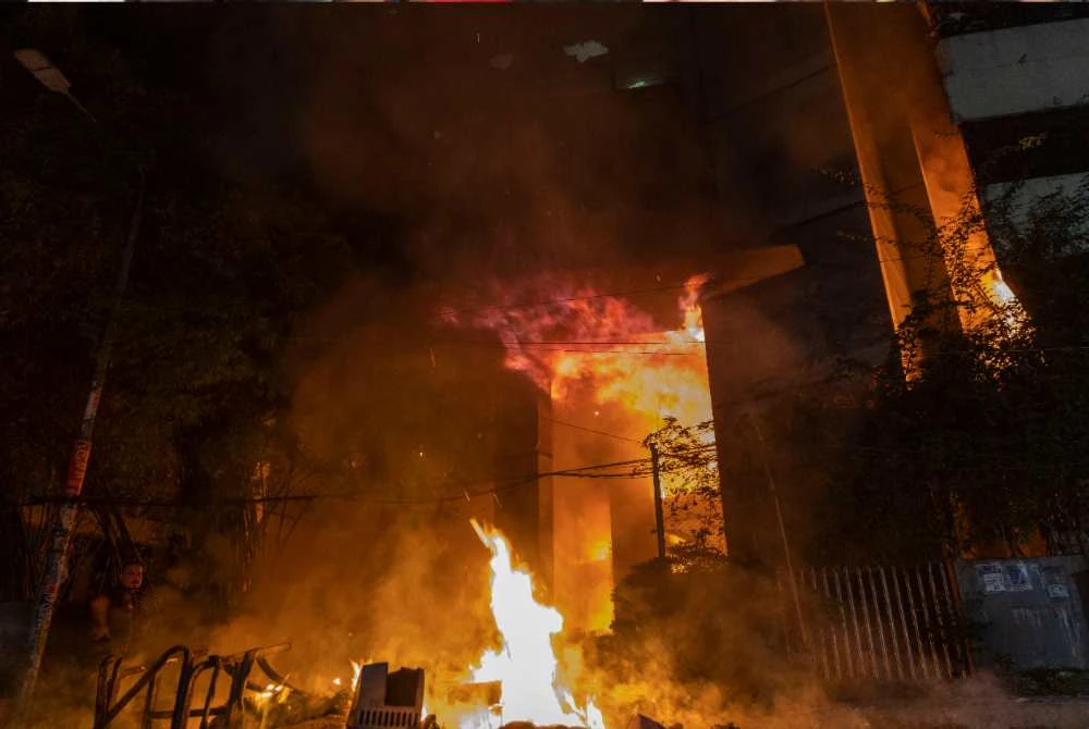 Api marak di bangunan akhbar The Daily Star di Dhaka ketika protes tercetus susulan kematian Hadi.- AFP