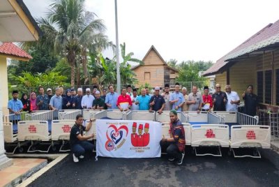 Ahli-ahli Tiga Abdul bergambar bersama tetamu khas dan pengurusan kariah pada majlis penyampaian katil hospital. 