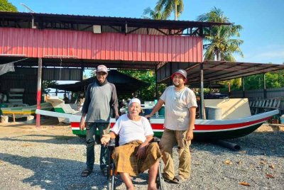 Md Ali bersama dua anaknya, Mohd Muzni dan Muzafar (kanan) yang mengendalikan bengkel pembuatan bot.
