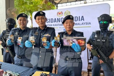 Wan Jamal Abdul Salam (dua dari kanan) bersama barisan pegawai menunjukkan rokok-rokok yang dirampas.