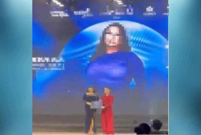 Tangkap layar memaparkan seorang lelaki berpakaian wanita menerima anugerah dalam satu majlis bertaraf antarabangsa 