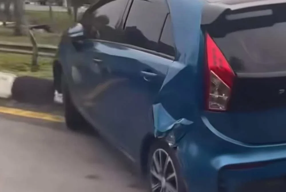 Proton Iriz mengalami kerosakan luaran selepas dihimpit treler dalam kejadian di R&R Jejantas Ayer Keroh, Melaka.
