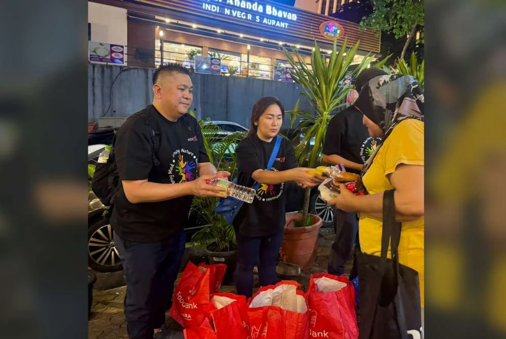 Sukarelawan redONE Mobile mengagihkan pek makanan kepada komuniti gelandangan dan miskin bandar di Kuala Lumpur.