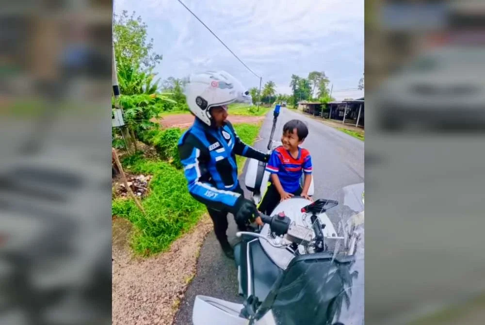 Kanak-kanak diberi peluang menaiki motosikal polis.