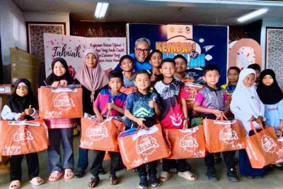 Azran Fitri (belakang) bersama sebahagian daripada 300 murid yang menerima sumbangan set kelengkapan 'Kembali Ke Sekolah - PEMASIK' di Sekolah Kebangsaan Seri Dusun, Sik pada Sabtu lalu.