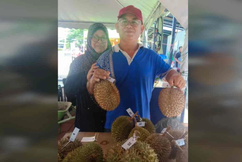 Nor Hisham (kanan) menunjukkan durian bergred tinggi yang ada dijual di pasaran tempatan.