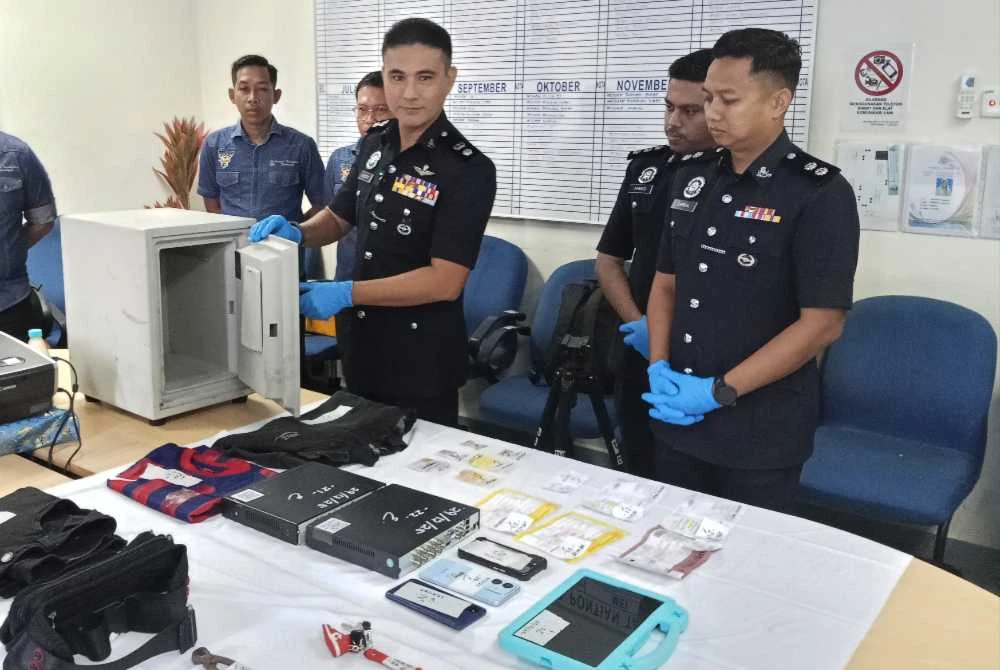 Hadzrat (dua dari kanan) menunjukkan peti besi yang dirampas daripada suspek pada sidang akhbar di IPD Pontian.