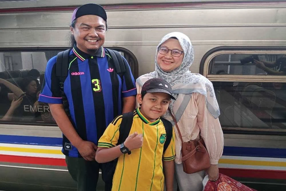 Muhd Arifuddin (kiri) bersama isteri dan anaknya menaiki tren ES di Stesen Keretapi JB Sentral.