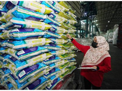 Seorang pekerja melakukan pemeriksaan stok beras Cap Astana di gudang penyimpanan.