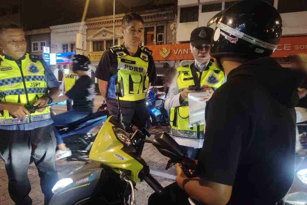 Mohd Zamzuri (kiri) dan Mohd Azani melaksanakan pemantauan Op Samseng Jalanan di sekitar ibu negara pada Khamis.