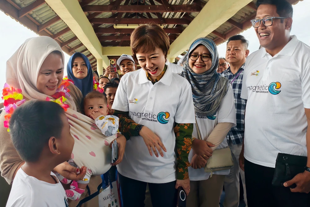 Nicole (tengah) beramah mesra dengan seorang pelancong kanak-kanak dari Indonesia yang baru tiba di Jeti Penumpang Port Dickson.