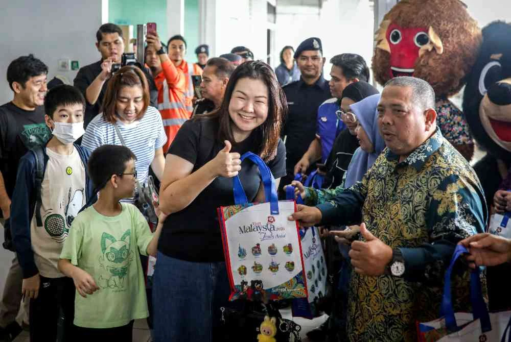 Abu Bakar (kanan) menyambut pengunjung sempena Tahun Melawat Malaysia dan Tahun Melawat Perlis 2026 di Stesen KTMB Padang Besar, pada Khamis. Foto Bernama