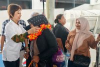 Nicole menyarung kalungan bunga pada pelancong Indonesia yang tiba di Jeti Penumpang Port Dickson pada Khamis.