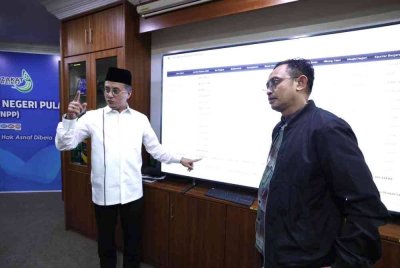 Mohamad (kiri) menunjukkan angka bagi kutipan Zakat MAINPP bagi tahun lalu.