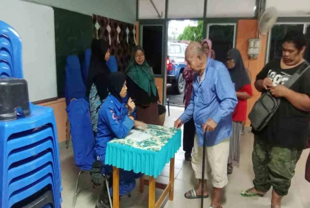 Proses pendaftaran mangsa banjir yang dipindahkan ke PPS SK Ulu Atok, Raub. Foto APM Pahang