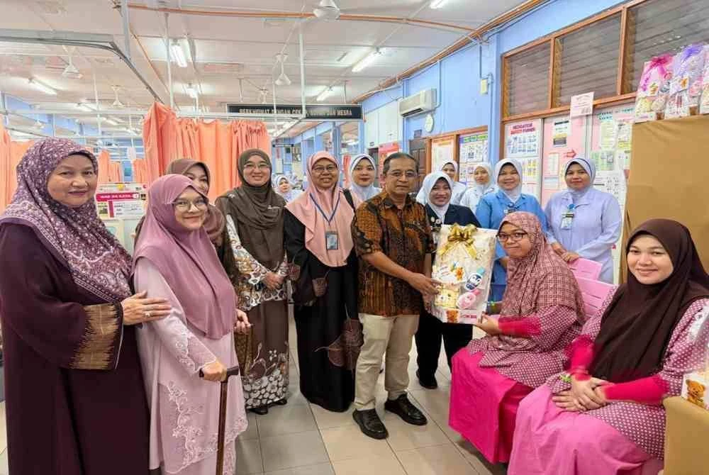 Dr Izamin menyampaikan cenderamata kepada ibu bayi Tahun Baharu 2026 dalam satu majlis sambutan khas yang diadakan di HRPZ II. Foto HRPZ II