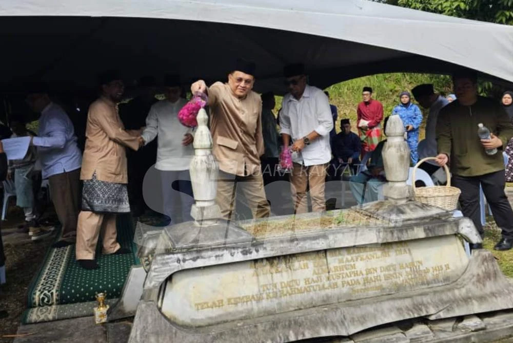 Mohd Arifin ketika menyiram air mawar di makam Tun Mustapha di Taman Memorial Tun Datuk Mustapha di Putatan pada Jumaat.