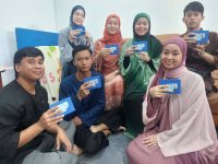 Nur Hakika (belakang, kiri) bersama enam adik-beradiknya gembira menerima kad pengenalan selepas dikunjungi JPN di rumah mereka di Bandar Sungai Buaya, Rawang pada Jumaat.